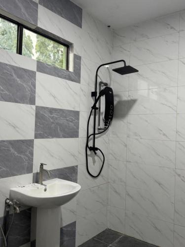 a bathroom with a shower head and a sink at Pandan Hotel in Papar