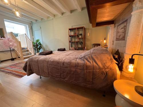 Un dormitorio con una cama grande en una habitación. en Cozy two-room city center apartment with garden, en Amersfoort