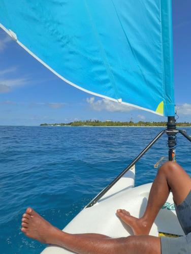 a person sitting on a sail boat in the water at Noah Private Beach House in Himmafushi