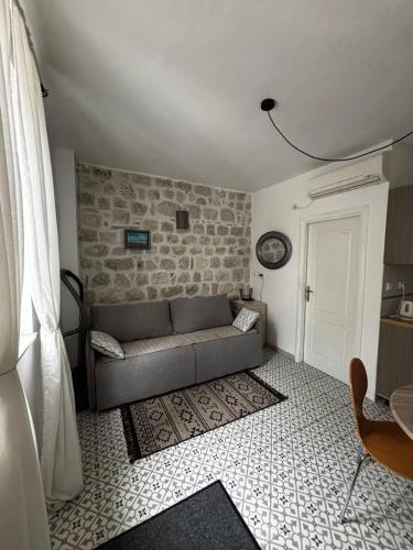 a living room with a couch and a brick wall at Apartment Katarina in Risan