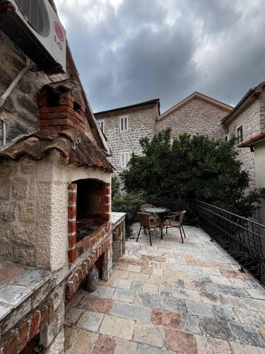 an outdoor brick oven with a table in a yard at Apartment Katarina in Risan