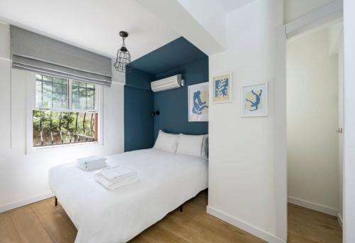 a bedroom with a white bed and a blue wall at Beautiful Modern Bright 2bd Patio Duplex #179 in Istanbul