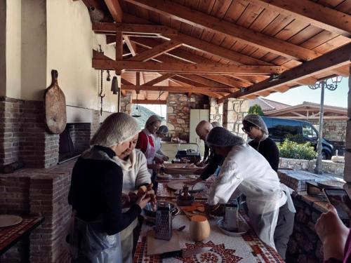 a group of people standing around a table in a kitchen at Arcadianis lakeview villa at Psari Arkadias in Psárion