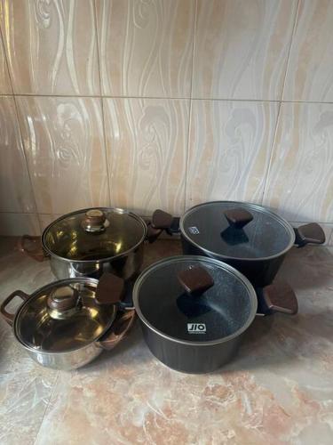 a group of three pots and pans sitting on a counter at Karibu Homestay in Moshi