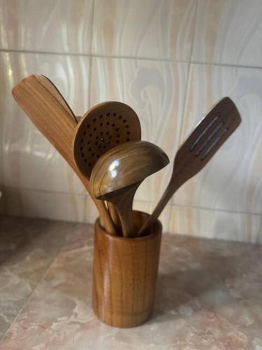 a wooden cup filled with utensils and a fork at Karibu Homestay in Moshi