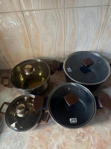 three pots and pans sitting on top of a stove at Karibu Homestay in Moshi