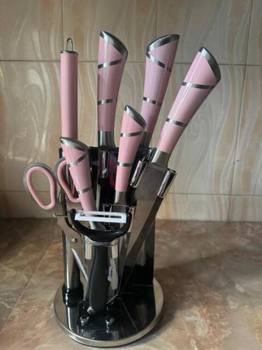 a vase filled with pink utensils on a counter at Karibu Homestay in Moshi
