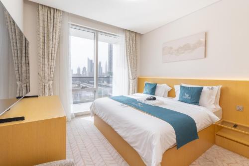 ein Schlafzimmer mit einem großen Bett und einem großen Fenster in der Unterkunft Vida Dubai Mall Balcony with Burj & City Views walk to Dubai Mall by Heaven Crest Vacation Homes in Dubai