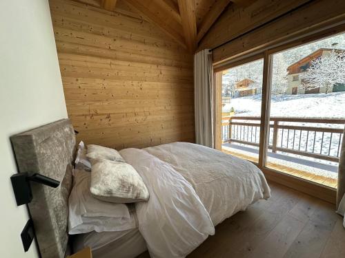 a bedroom with a bed and a large window at CHALET ALIET 1500 - 18 personnes PEISEY NANCROIX - LES ARCS - LA PLAGNE - PARADISKI in Peisey-Nancroix