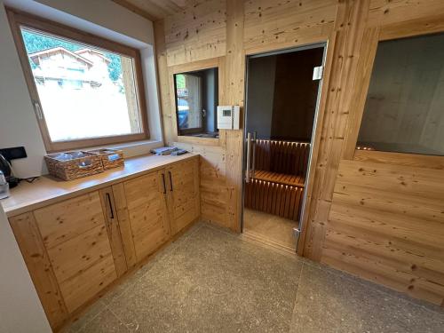 a kitchen with wooden cabinets and a large window at CHALET ALIET 1500 - 18 personnes PEISEY NANCROIX - LES ARCS - LA PLAGNE - PARADISKI in Peisey-Nancroix