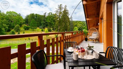 una mesa en un balcón con vistas a un campo en Apartamenty Good Time - Z widokiem na góry, en Szklarska Poręba