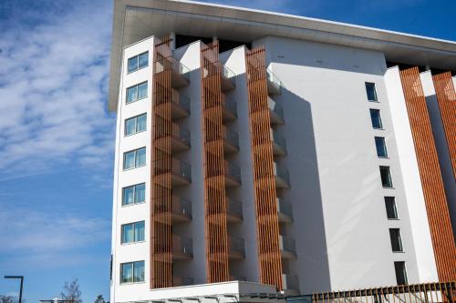 a tall white building with a sky in the background at PINEA Resort in Pobierowo
