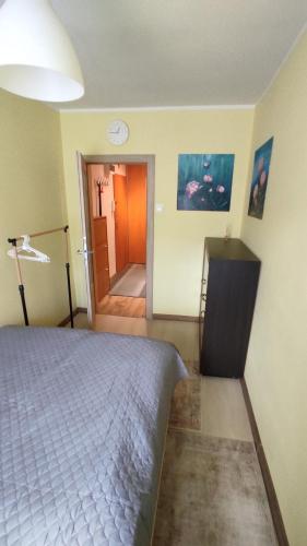 a bedroom with a bed and a door to a hallway at Apartament pod Górą Chełmską in Koszalin