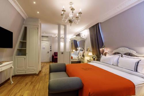 a bedroom with a large bed with an orange blanket at Amiral Palace Hotel Boutique Class in Istanbul