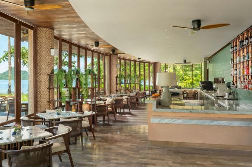 a restaurant with tables and chairs and windows at Lampung Marriott Resort & Spa in Lampung
