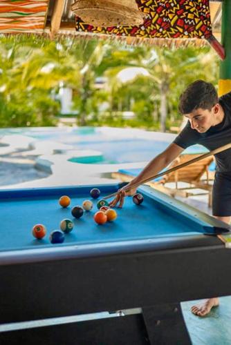 a man playing pool on a pool table at Kameleon Blue in Kizimkazi