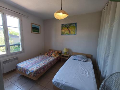une chambre avec deux lits et une fenêtre dans l'établissement Maison provençale avec piscine partagée, à Loriol-du-Comtat
