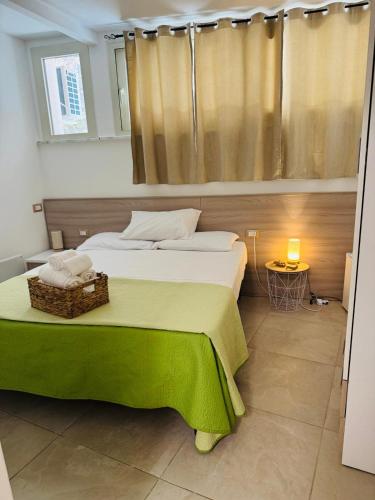 a bedroom with a large bed with a green blanket at La Finestrella in Belvedere Marittimo