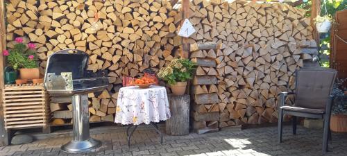 a wall with a pile of wood next to a table at Relax apartma Peter in Ptuj