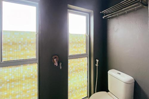 bagno con servizi igienici e 2 finestre di RedDoorz at Kanaka Hostel Tanjung Pinang a Tanjung Pinang
