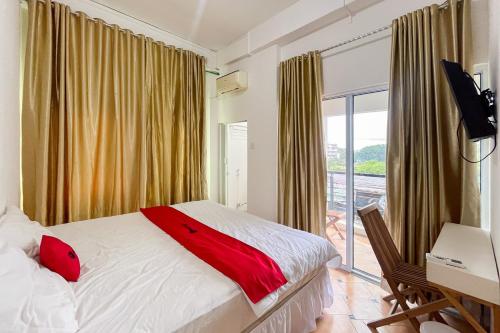 una camera da letto con un letto e una grande finestra di RedDoorz at Kanaka Hostel Tanjung Pinang a Tanjung Pinang
