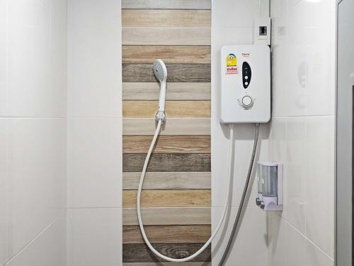 a shower in a bathroom with a hose attached to a wall at Norn nee Na Hostel นอน นี่ นะ โฮสเทล in Ban Non Na Yao