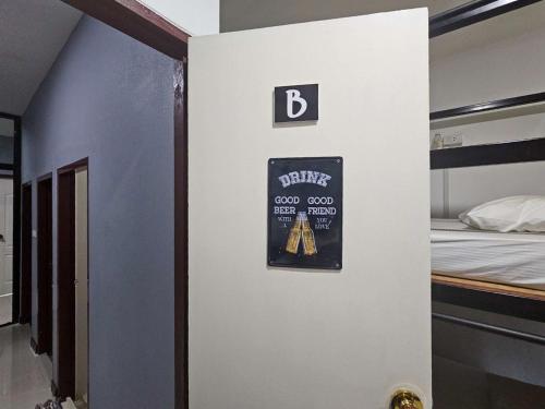 a room with a bed and a sign on a wall at Norn nee Na Hostel นอน นี่ นะ โฮสเทล in Ban Non Na Yao