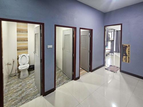 a bathroom with doors and a toilet in a room at Norn nee Na Hostel นอน นี่ นะ โฮสเทล in Ban Non Na Yao