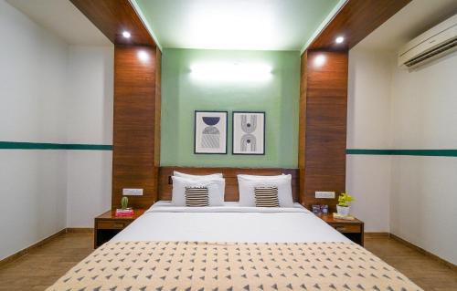 a bedroom with a bed and a green wall at Olive Hotel Electronic City by Embassy Group in Bengaluru