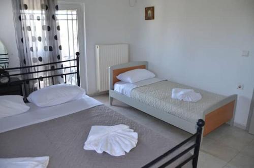two beds in a room with towels on them at Villa Esperado Gardens Maleme in Maleme