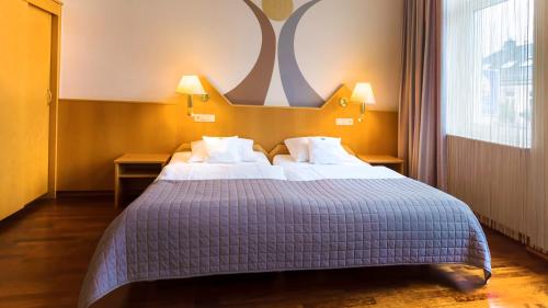 a hotel room with a large bed and a window at Komfort Hotel Am Kurpark in Bad Homburg vor der Höhe