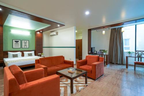 a hotel room with a bed and a couch and chairs at Olive Hotel Electronic City by Embassy Group in Bengaluru