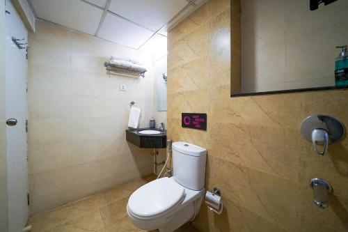 a bathroom with a white toilet and a sink at Olive Hotel Electronic City by Embassy Group in Bengaluru