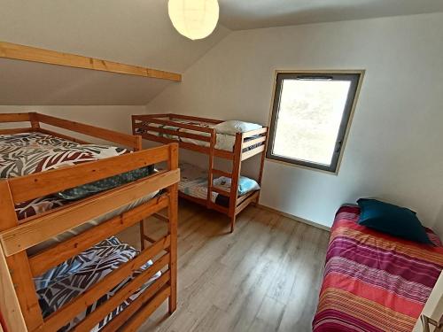 a bedroom with two bunk beds and a window at Chalet de l'Aiguille Noire in Montricher-Albanne