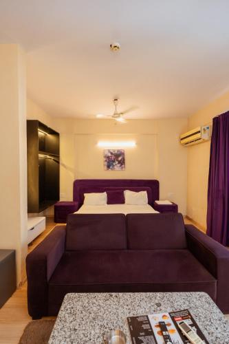 a living room with a couch and a bed at Skystay Lucknow in Lucknow
