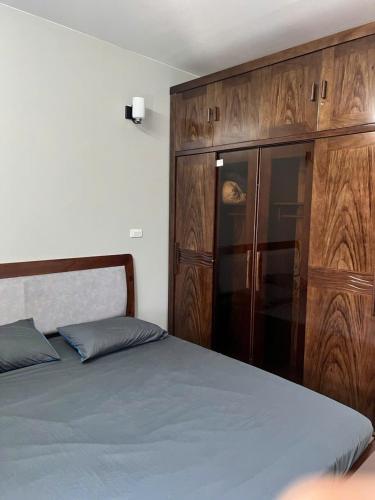 a bedroom with a bed and a wooden cabinet at Căn Hộ Hướng Biển Xem pháo hoa gần Vincom,Bảo Tàng Quảng Ninh in Ha Long