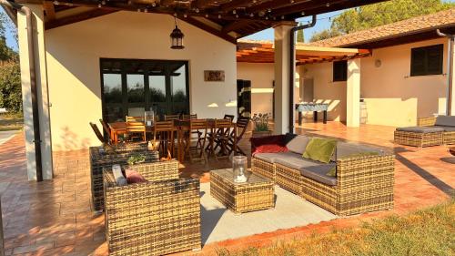 a patio with a couch and chairs and a table at Maremma Design in Manciano