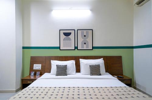 a bedroom with a bed with three pictures on the wall at Olive Hotel Electronic City by Embassy Group in Bengaluru
