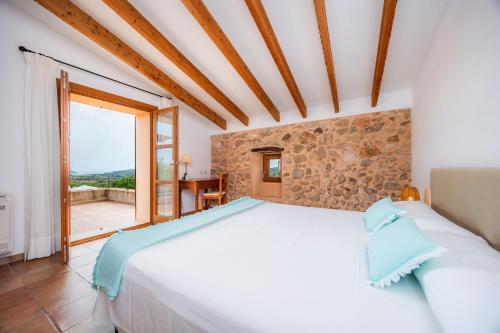 a bedroom with a large bed and a large window at Els Clepes in Son Servera