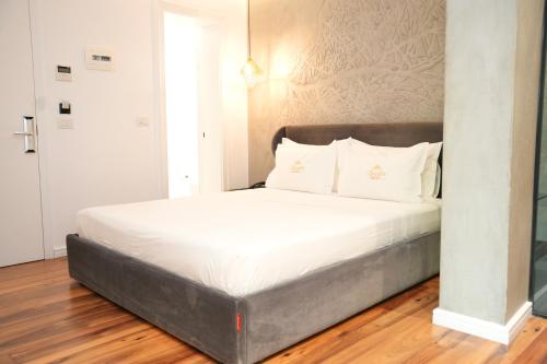 a bed with white sheets and pillows in a room at La Suite Boutique Hotel in Tirana