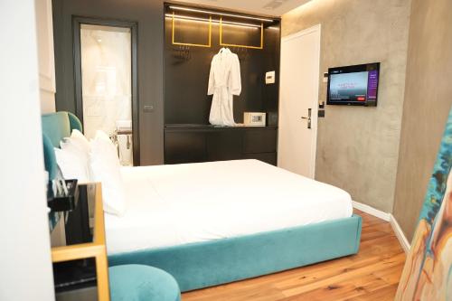 a bedroom with a white bed and a tv at La Suite Boutique Hotel in Tirana