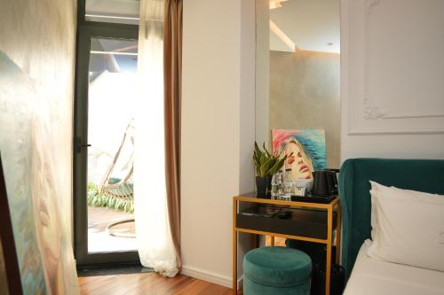a bedroom with a mirror and a chair and a table at La Suite Boutique Hotel in Tirana