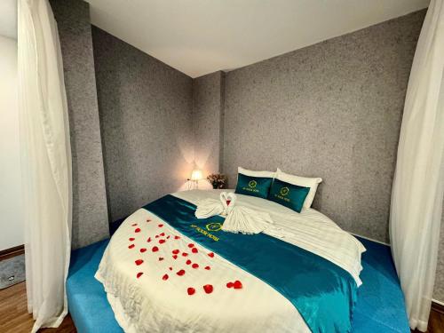 a bedroom with a bed with red roses on it at My House Hotel Hanoi in Hanoi