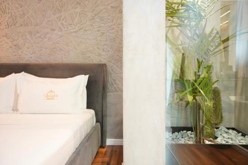 a bedroom with a bed and a vase on a table at La Suite Boutique Hotel in Tirana