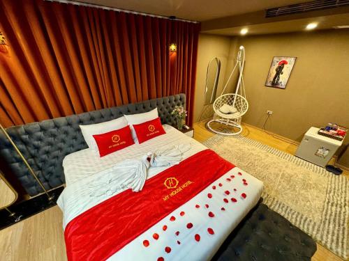 a bedroom with a large bed with red pillows at My House Hotel Hanoi in Hanoi