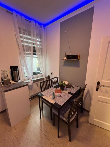 a dining room with a table and chairs and a kitchen at Best Preis Stadtperle 1- Stadtzentrum Wittenberge Modernes Ambiente max 3 Personen Einzelzimmer voll ausgestattet mit MagentaTV, WLAN, Waschmaschine in Wittenberge