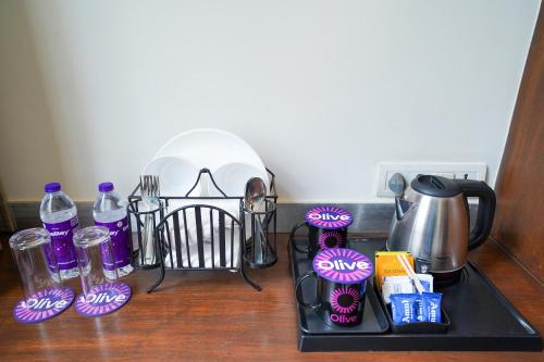 a counter top with a coffee pot and utensils at Olive Hotel Electronic City by Embassy Group in Bengaluru