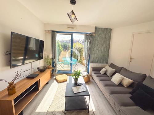 a living room with a couch and a flat screen tv at COC - Entre Terre Et Mer in Wissant