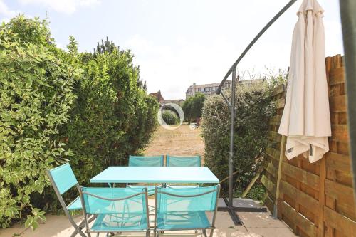 a table and chairs and an umbrella on a patio at COC - Entre Terre Et Mer in Wissant