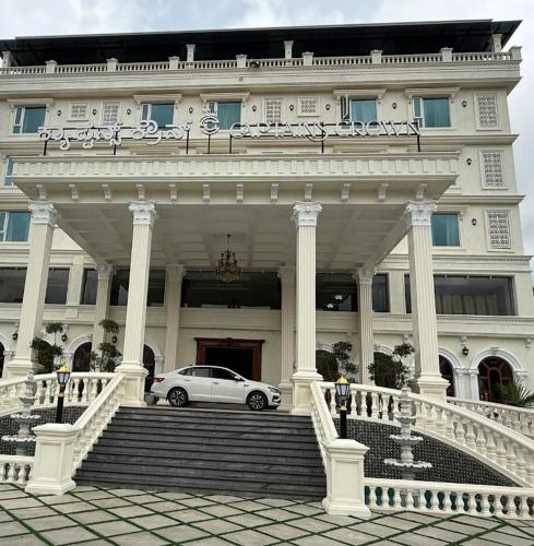 a white car parked in front of a building at Captains Crown Hotels & Resorts in Kushālnagar
